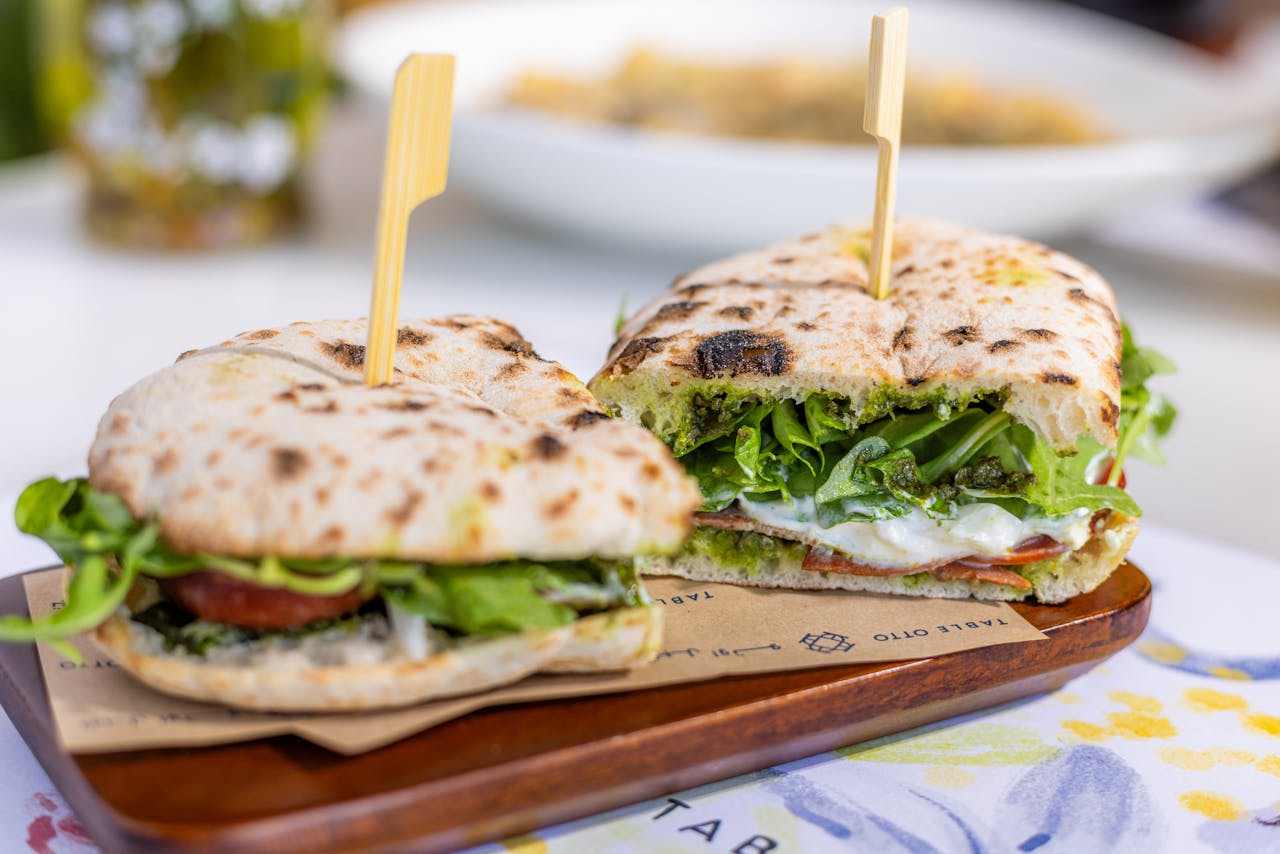 Delicious sandwich with greens, tomato, mozzarella, and pesto, perfect for a light meal.